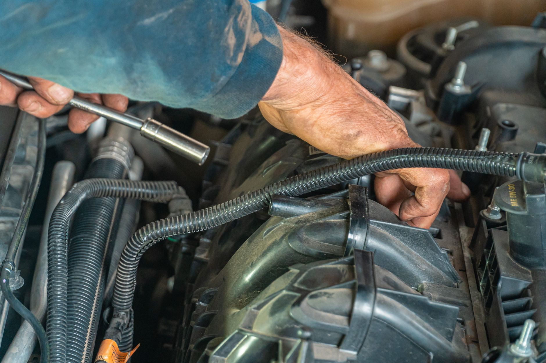 Mécanicien réparant le moteur d'une voiture au garage.