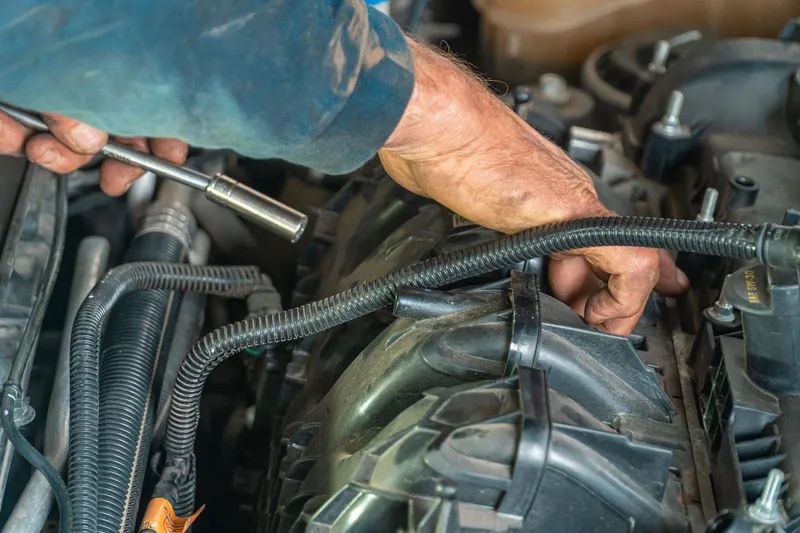 Mécanicien réparant le moteur d'une voiture au garage.